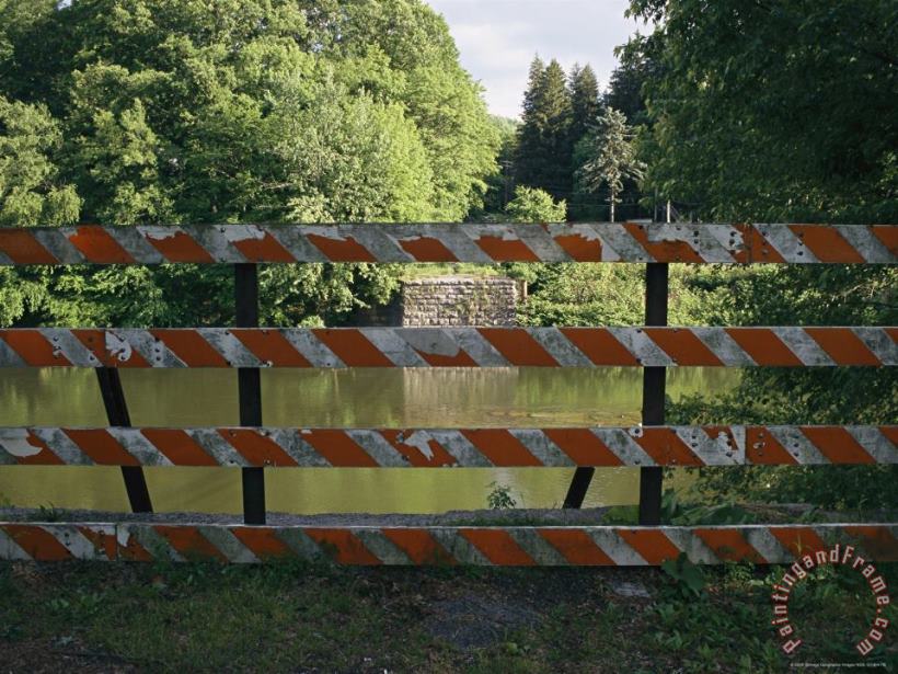 A Barricade Blocks The Road Where a Bridge Once Crossed The River painting - Raymond Gehman A Barricade Blocks The Road Where a Bridge Once Crossed The River Art Print
