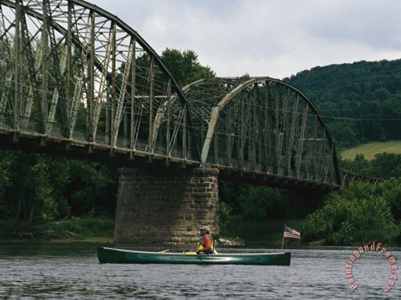 A Canoeist Passes Under a Bridge on The Susquehanna River painting - Raymond Gehman A Canoeist Passes Under a Bridge on The Susquehanna River Art Print