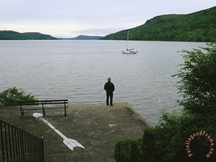 Raymond Gehman A Man Looks Out at a Sailboat Anchored on Otsego Lake Art Print