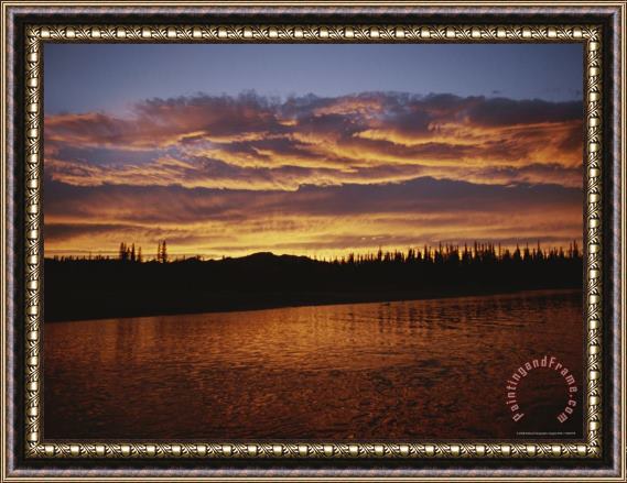 Raymond Gehman An Intense Sunset Colors Clouds And The Water of The Mackenzie River Framed Painting