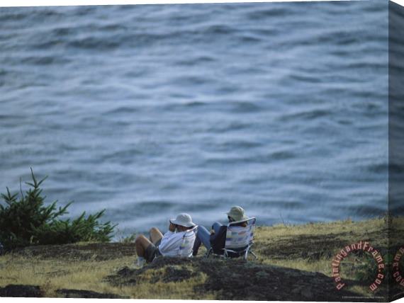 Raymond Gehman A Couple Sits on a Shore Observing Killer Whales Swimming Offshore Stretched Canvas Painting / Canvas Art