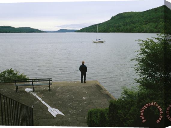 Raymond Gehman A Man Looks Out at a Sailboat Anchored on Otsego Lake Stretched Canvas Painting / Canvas Art