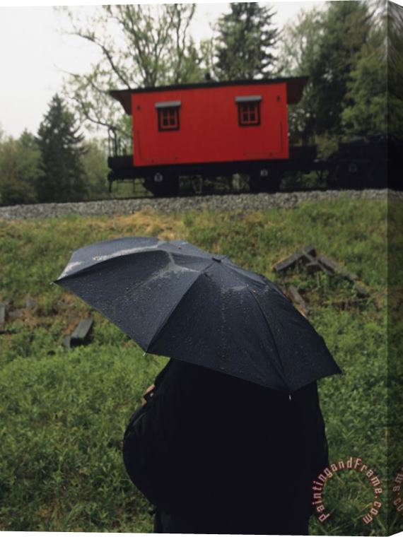 Raymond Gehman Person Under an Umbrella Looking at a Parked Train Caboose Stretched Canvas Print / Canvas Art
