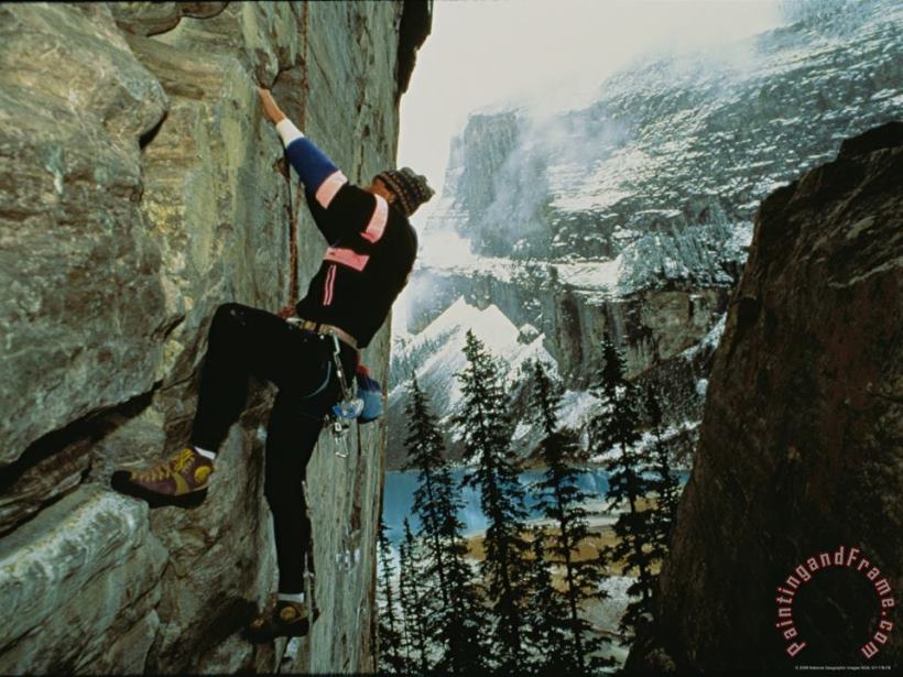 A Climber Ascends The Quartzite Cliffs at The End of Lake Louise painting - Raymond Gehman A Climber Ascends The Quartzite Cliffs at The End of Lake Louise Art Print