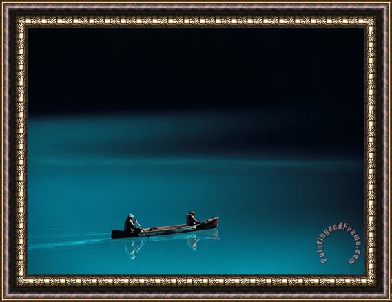 Raymond Gehman A Canoe Plies The Mirror Smooth Surface of Lake Louise Framed Painting