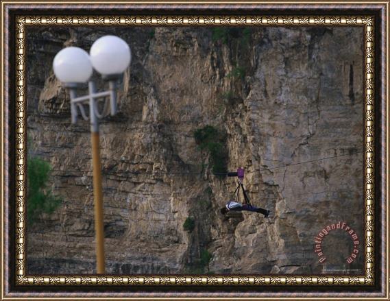 Raymond Gehman A Man Simulates Flying Using a Harness And Cable at a Resort Framed Painting