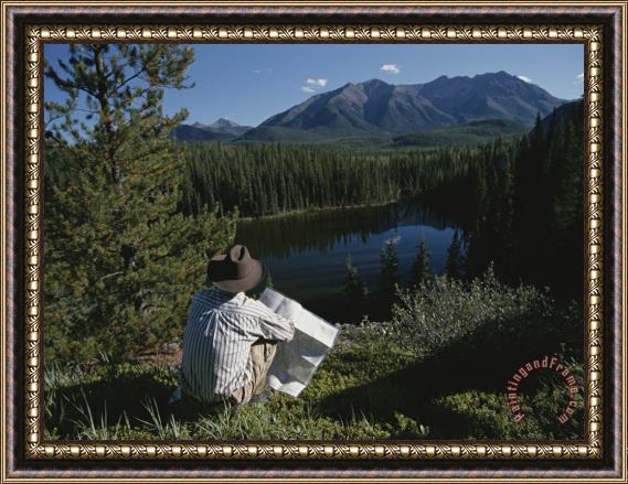 Raymond Gehman A Man with a Cowboy Hat Reads a Map And Gazes Across a River Framed Painting