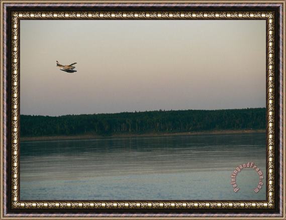 Raymond Gehman A Seaplane Soars Above The Mackenzie River at Dusk Framed Painting