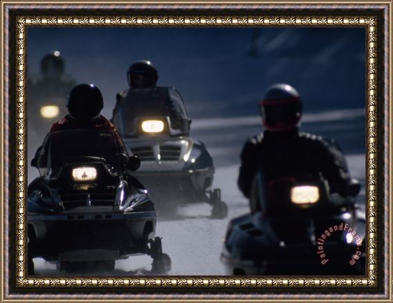 Raymond Gehman Snowmobilers Ride Down a Snowy Road in Yellowstone Park Framed Print