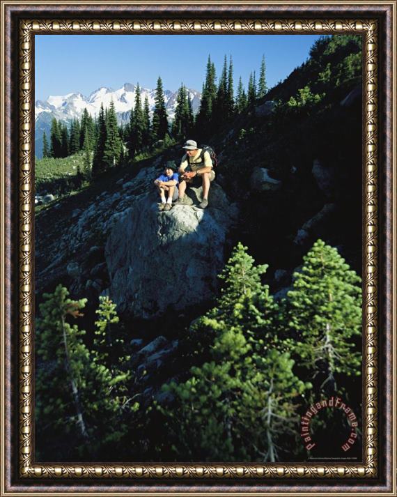 Raymond Gehman Two Hikers Rest on a Rock Amid Evergreen Trees Framed Painting