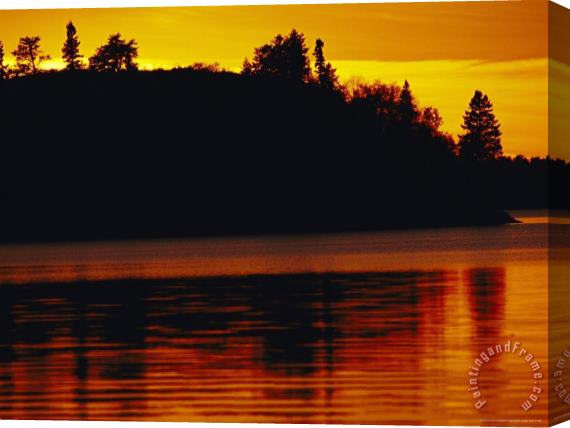 Raymond Gehman The Setting Sun Casts an Orange Glow Over Manitoba S White Lake Stretched Canvas Print / Canvas Art